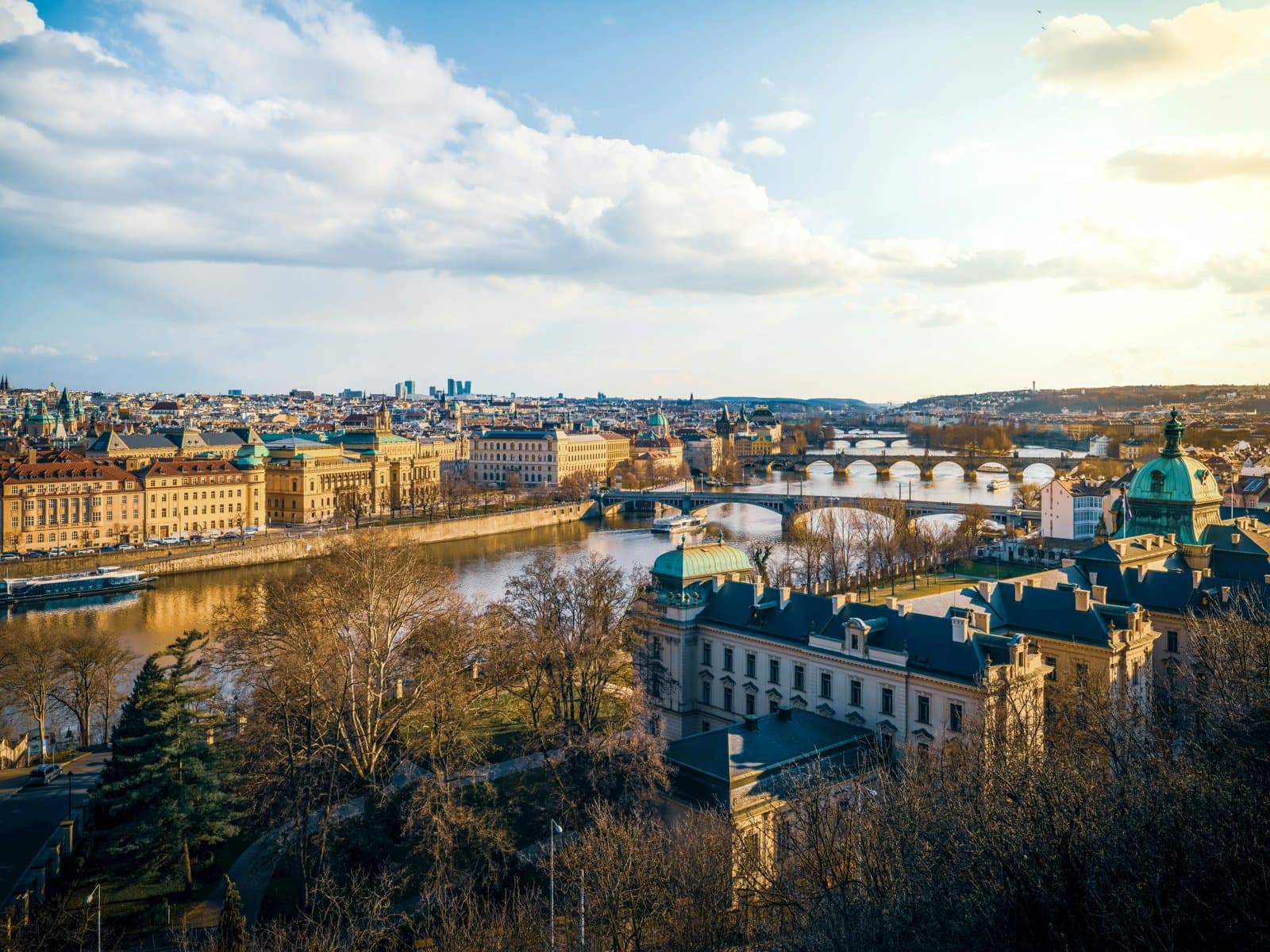 A beautiful aerial view of Prague showcasing its iconic bridges and river at sunset.