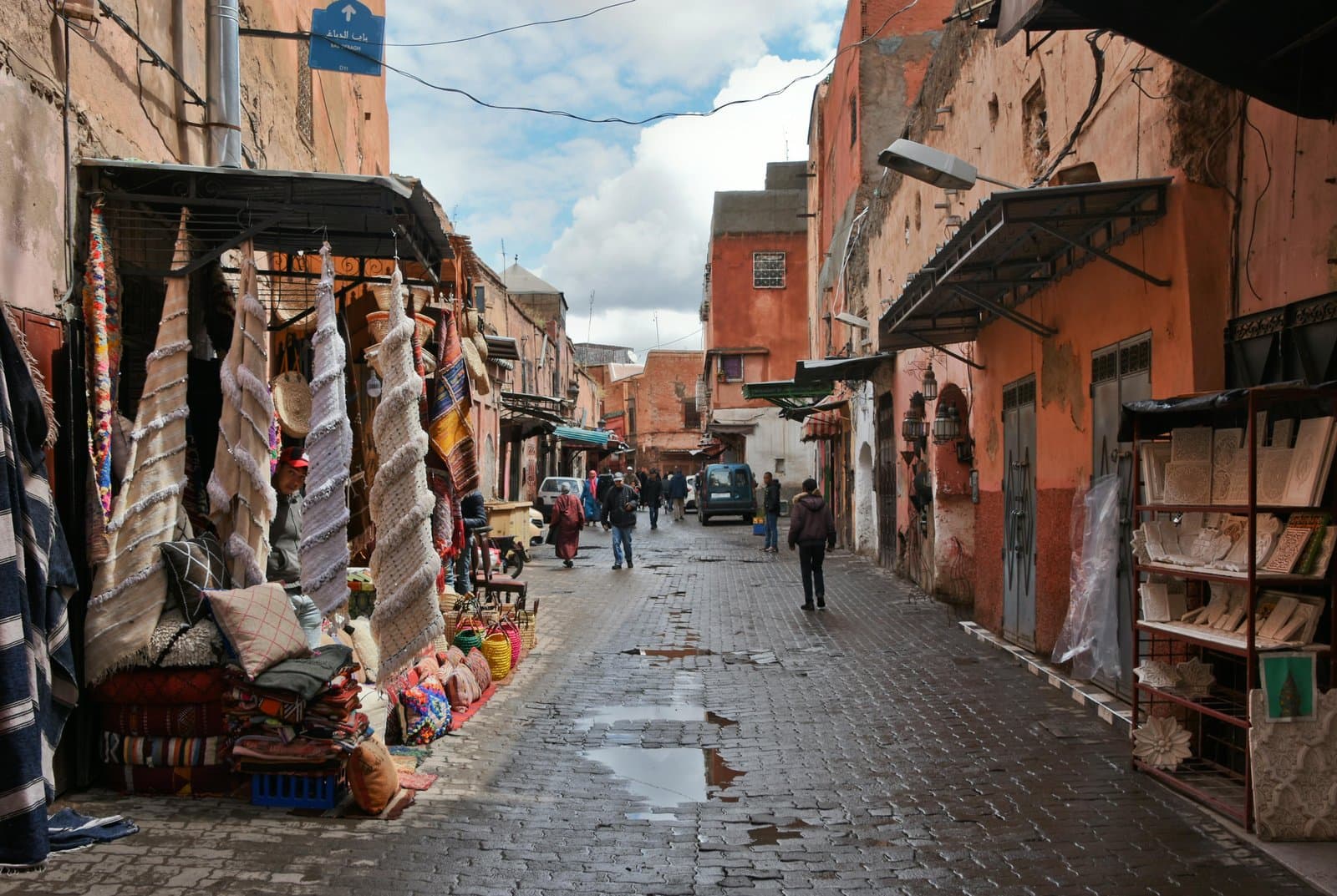 Explore the bustling streets of Marrakech with vibrant fabrics and traditional architecture in this lively market scene.