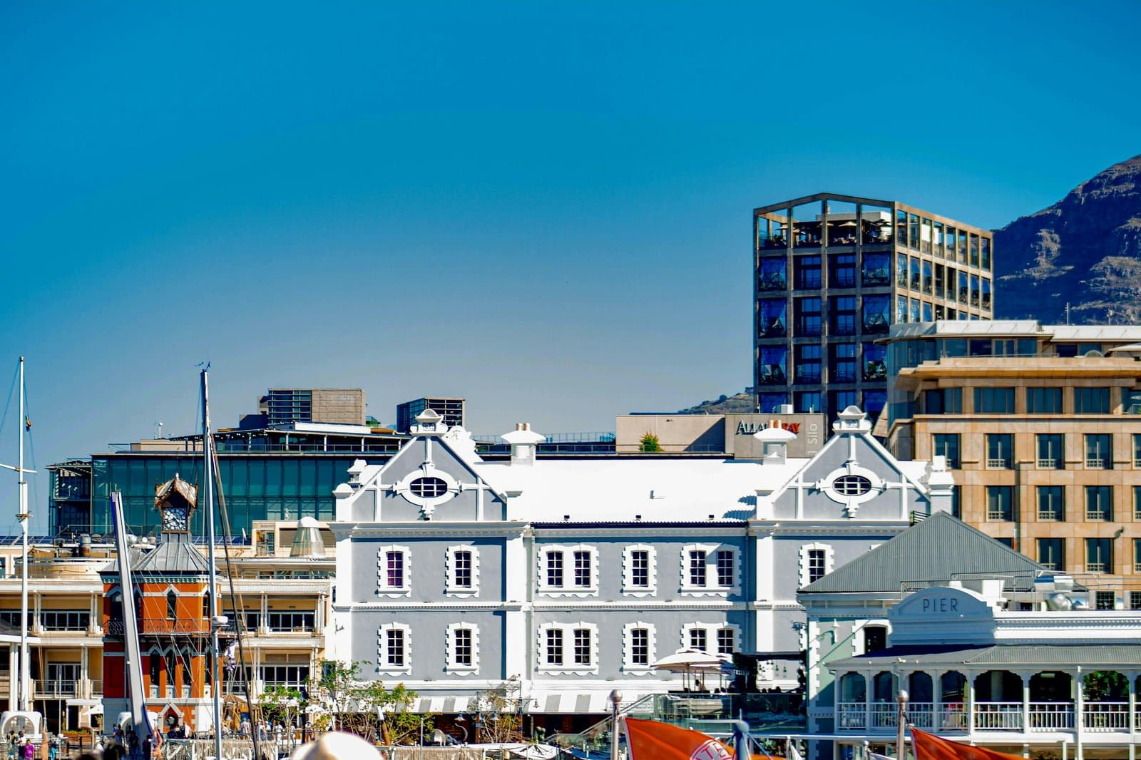 Scenic view of historic and modern buildings at Cape Town's waterfront with blue sky.