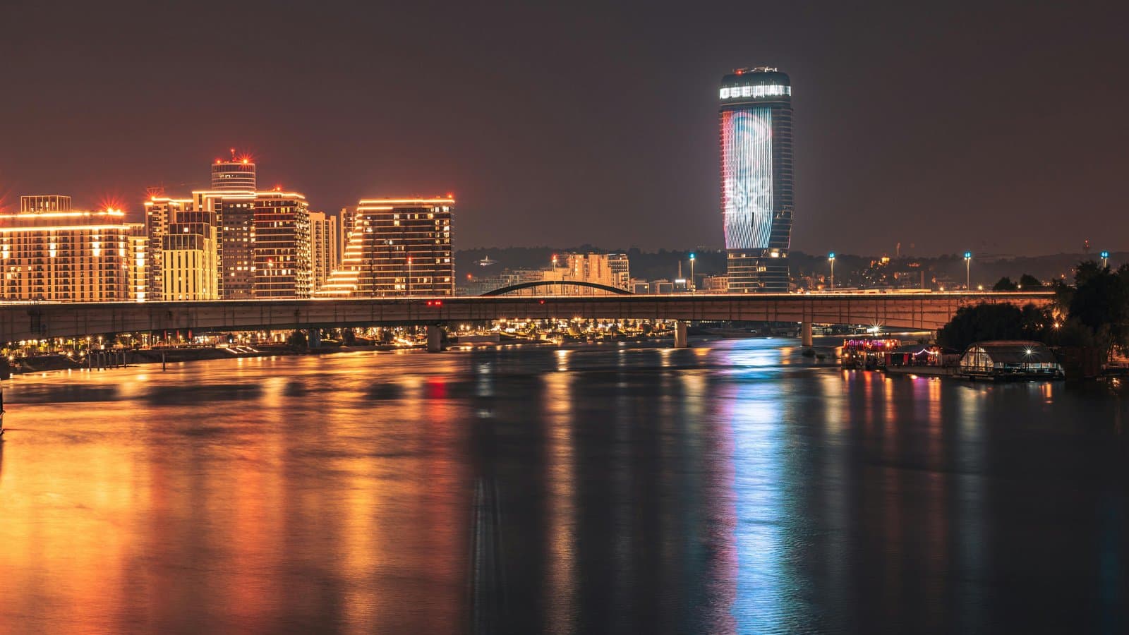 Stunning night view of Belgrade's illuminated skyline and river reflection, Serbia.